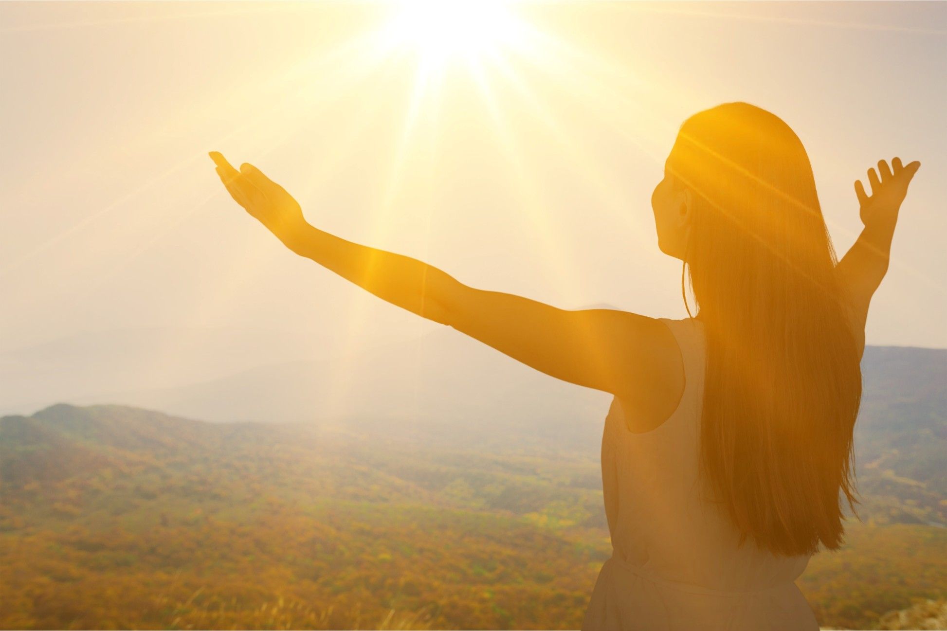 Woman raising her arms in sunlight, symbolising emotional recovery and wellbeing